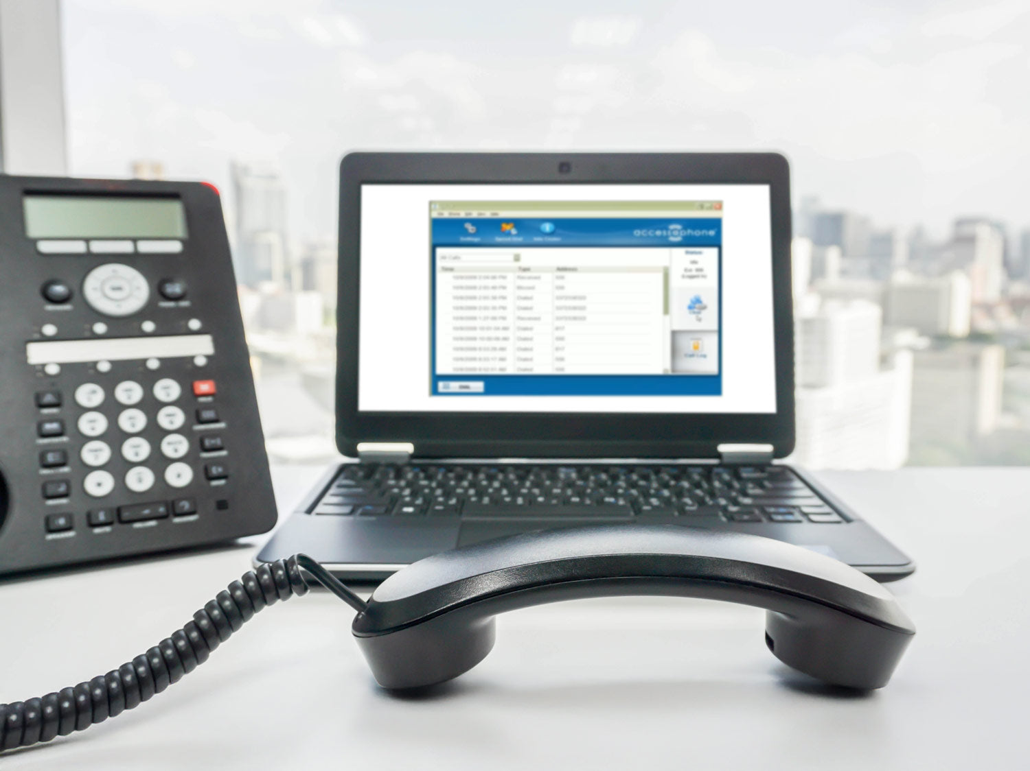 Handset resting in front of a laptop displaying the ipTTY application for real-time text communication